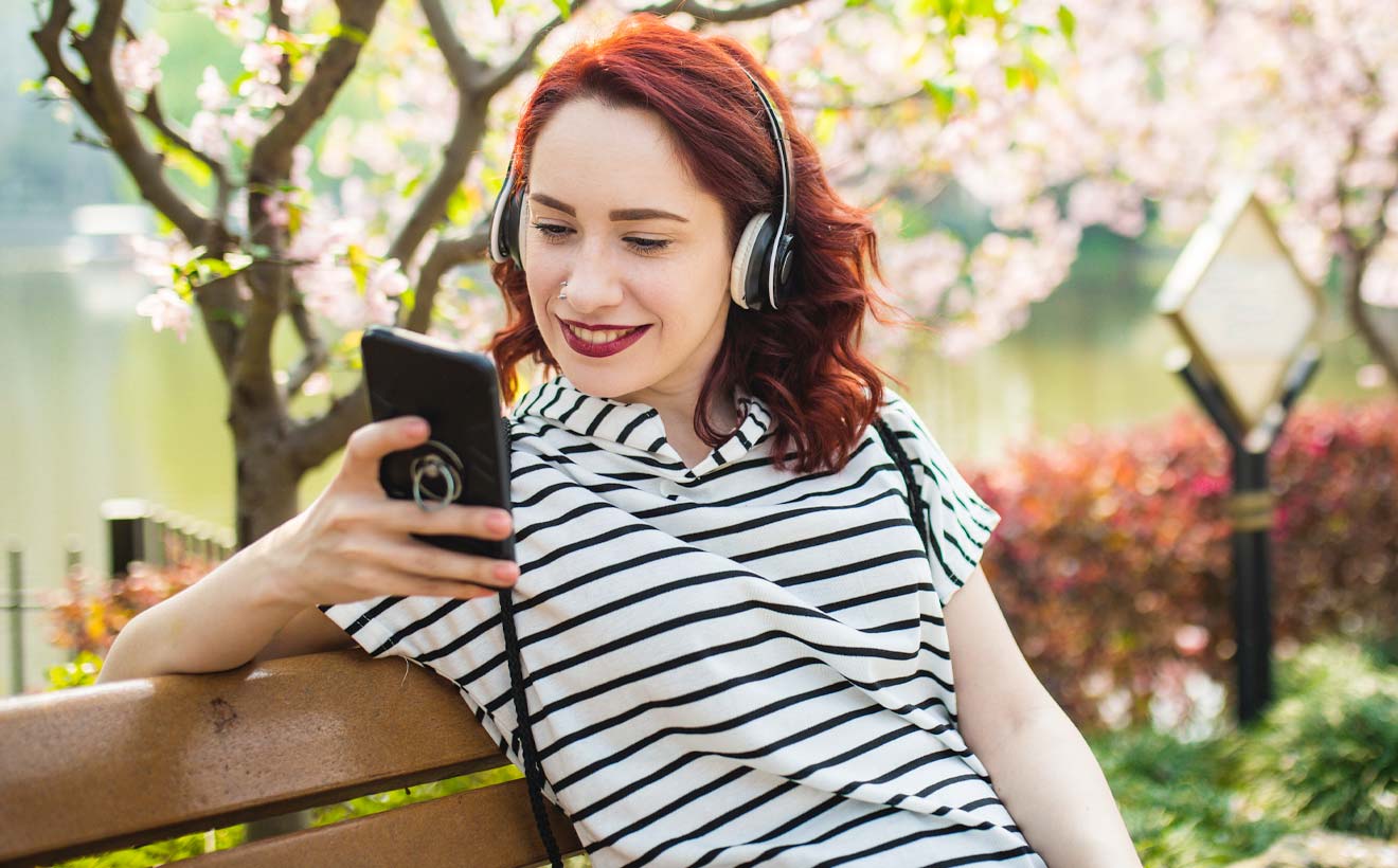 Junge Frau hört die RheinEnergie Podcasts zu den Themen Trinkwasser und Klimaschutz