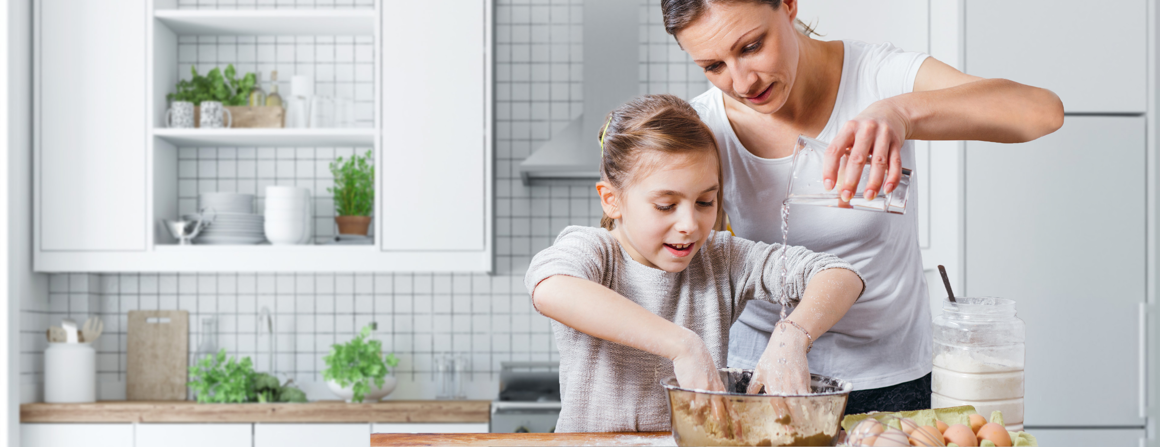Mutter und Tochter beim Backen in der Küche.