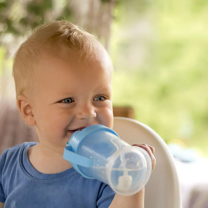 Kleinkind trinkt Wasser aus der Flasche.