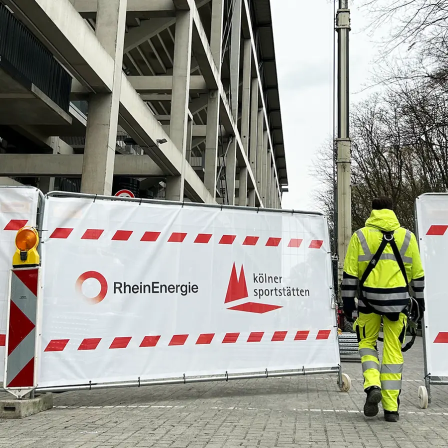 Ein Techniker der RheinEnergie betritt die Baustelle am RheinEnergieSTADION.