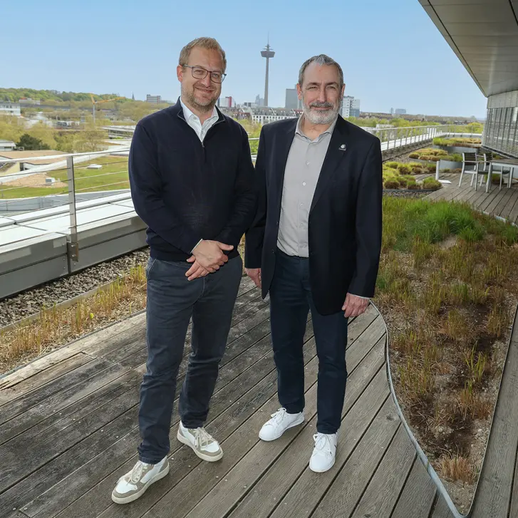Stephan Segbers und Marc Schmitz stehen auf der Terrasse der RheinEnergie Zentrale.