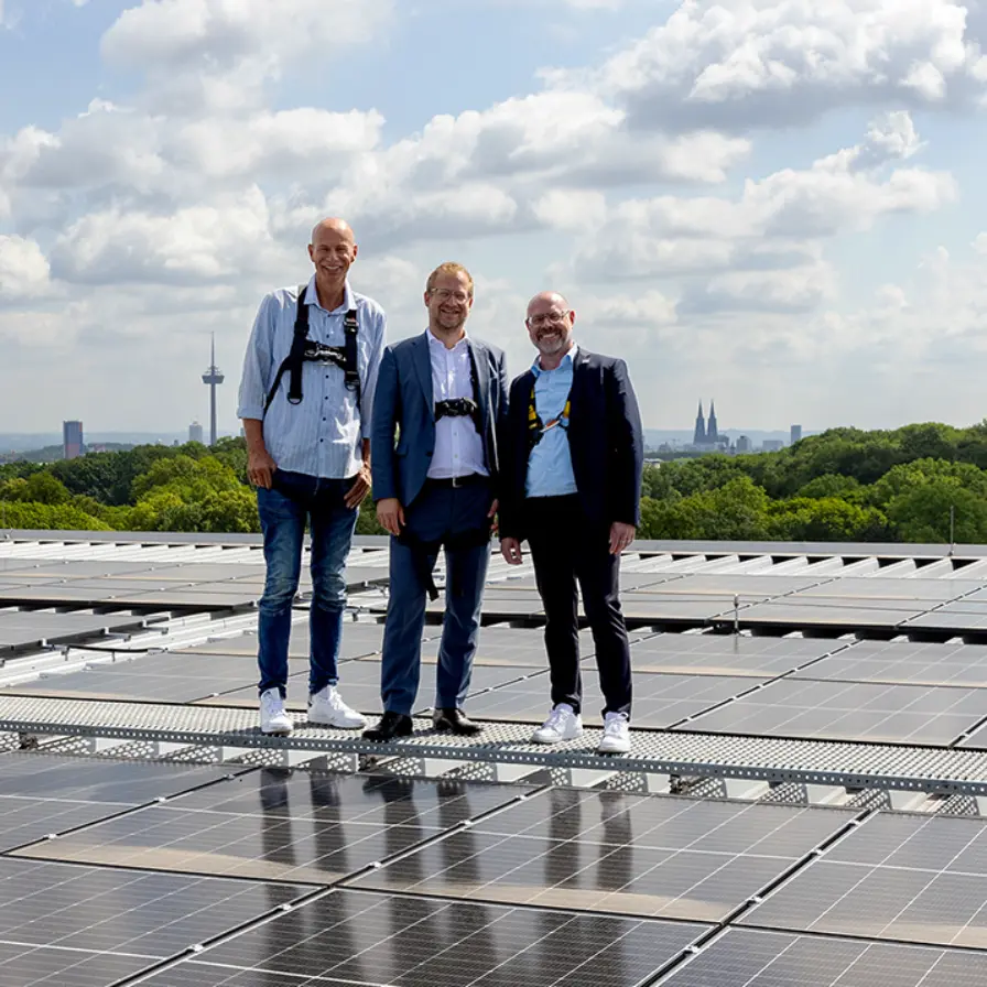 Lutz Wingerath, Stephan Segbers und Jörn Stobbe stehen auf dem Dach des RheinEnergieSTADION.