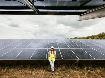 Projektleiterin Clara Ukat steht unter den PV-Modulen von Kölns aktuell größtem Solarpark.