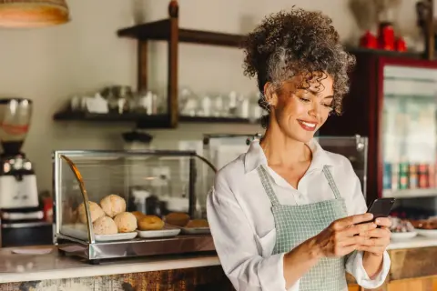 Kaffeebesitzerin am Handy