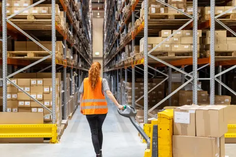 Mitarbeiterin in einem Hochregallager