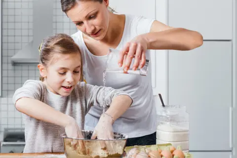 Mutter und Tochter beim Backen in der Küche.