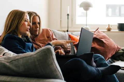 Ehepaar sitz in Küche vor Laptop