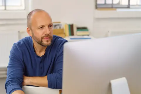Ein Mann sitzt vor einem Computer.