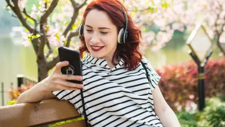 Junge Frau hört die RheinEnergie Podcasts zu den Themen Trinkwasser und Klimaschutz