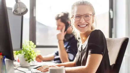 Zufriedene junge Frau im Büro der RheinEnergie