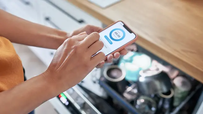 Ein Mann im Hemd hält ein Tablet und tippt darauf