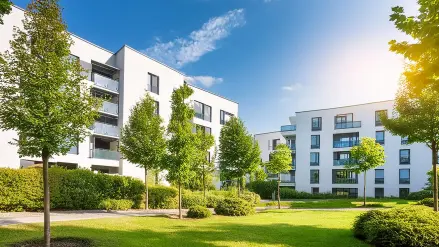 Weiße, moderne Häusersiedlung im Grünen.