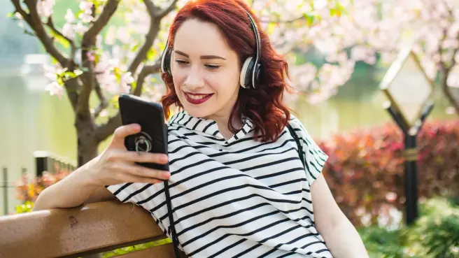 Junge Frau hört die RheinEnergie Podcasts zu den Themen Trinkwasser und Klimaschutz