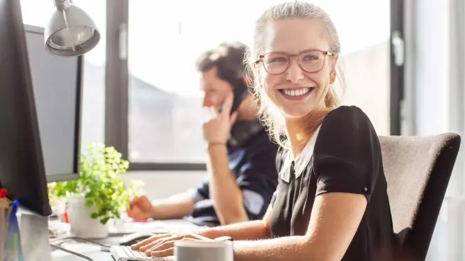 Zufriedene junge Frau im Büro der RheinEnergie
