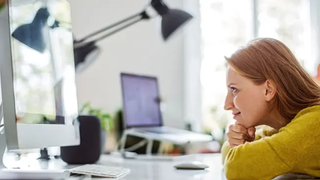 Junge Frau schaut auf den Monitor.