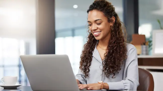 Junge Frau sitzt am Laptop.