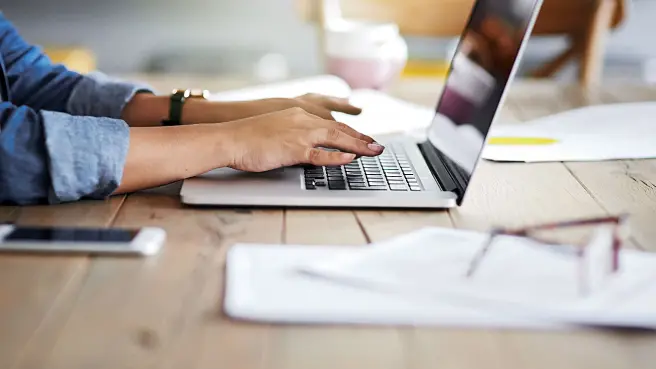 Person schreibt auf dem Laptop.