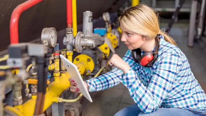 Eine Handwerkerin prüft ein Ventil