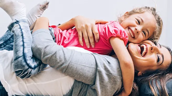 Mutter und Tochter kuscheln auf dem Sofa.