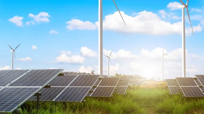 Eine Photovoltaik-Anlage vor Windrädern