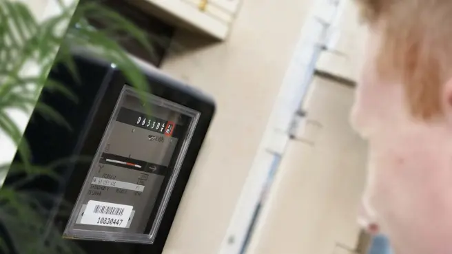 Mann liest Stromzähler ab