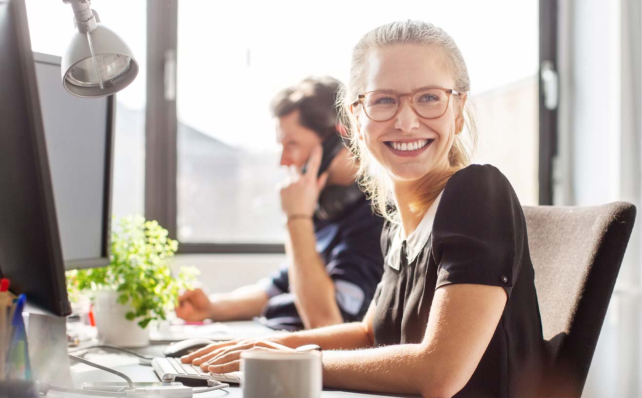 Zufriedene junge Frau im Büro der RheinEnergie