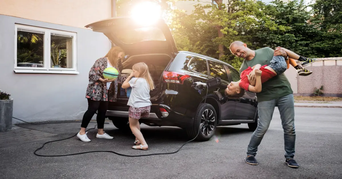 Auto im Hof, Familie am Elektroauto