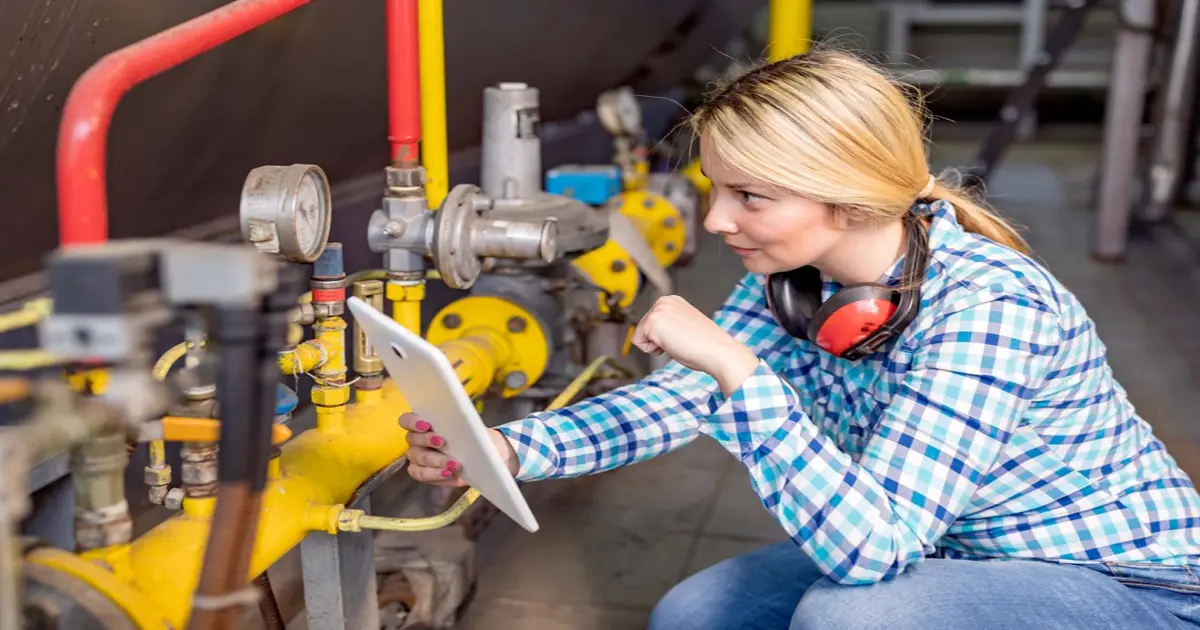 Eine Handwerkerin prüft ein Ventil