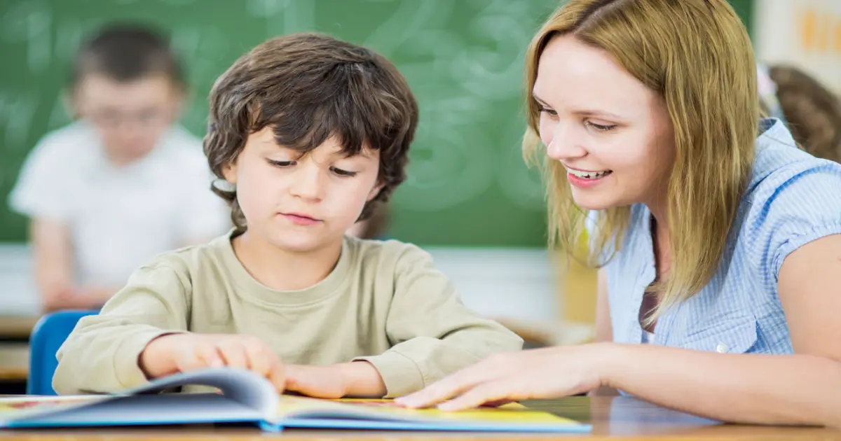 Kind und Lehrerin im Klassenraum