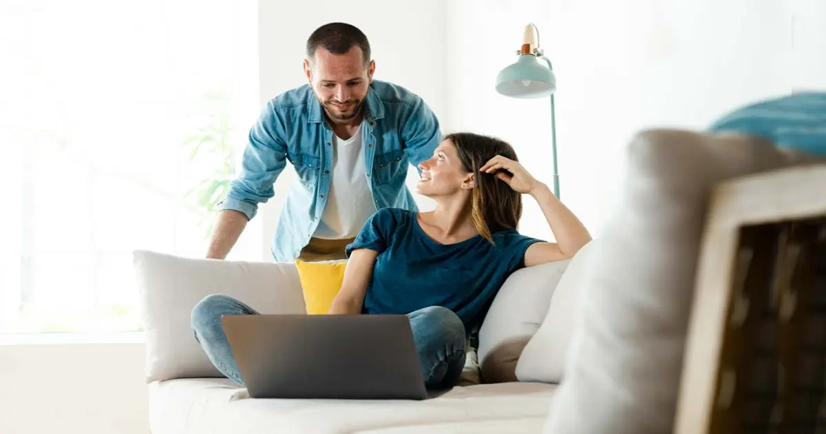 Paar mit Laptop auf Sofa