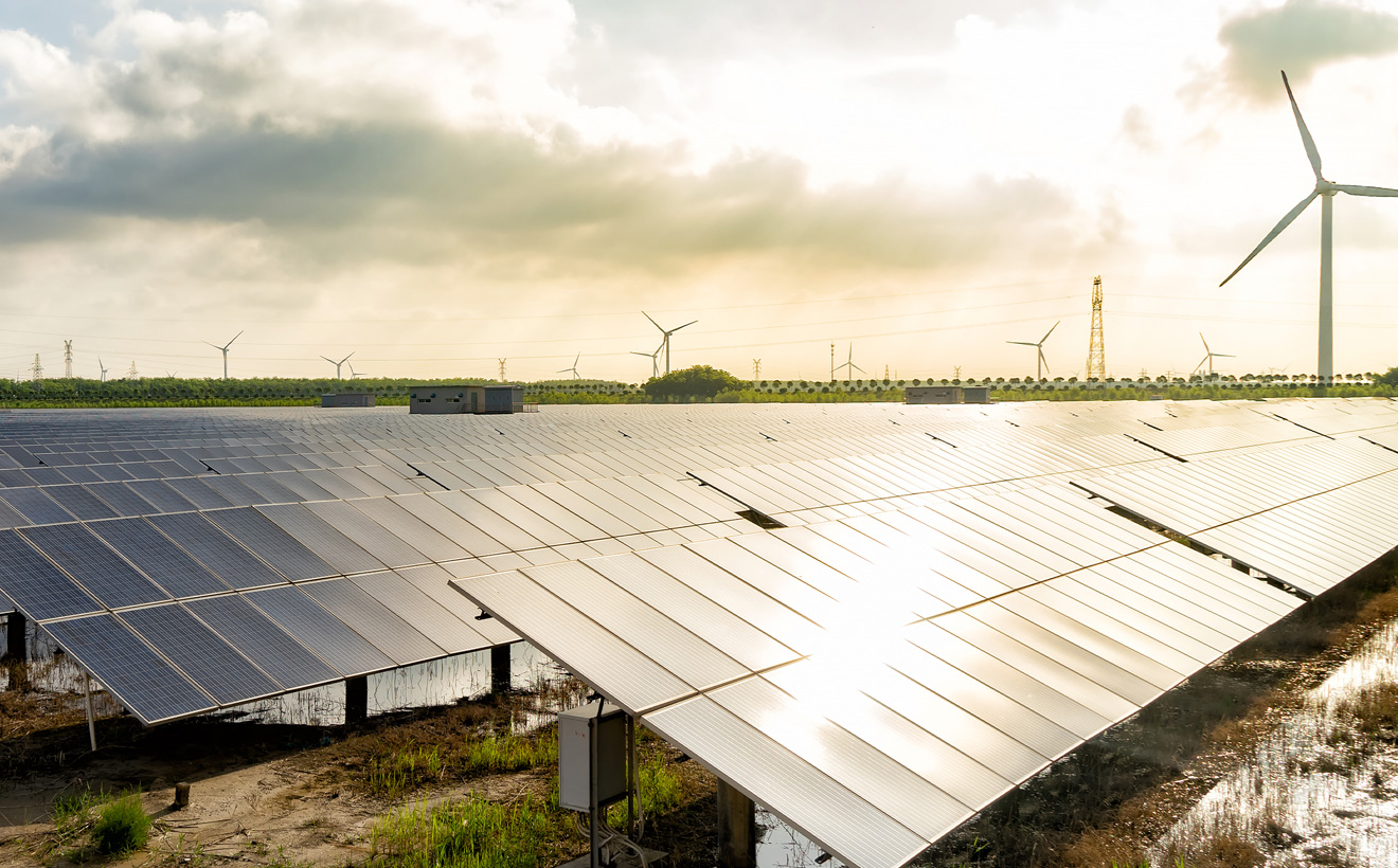 Eine Solaranlage mit Windrad im Hintergrund