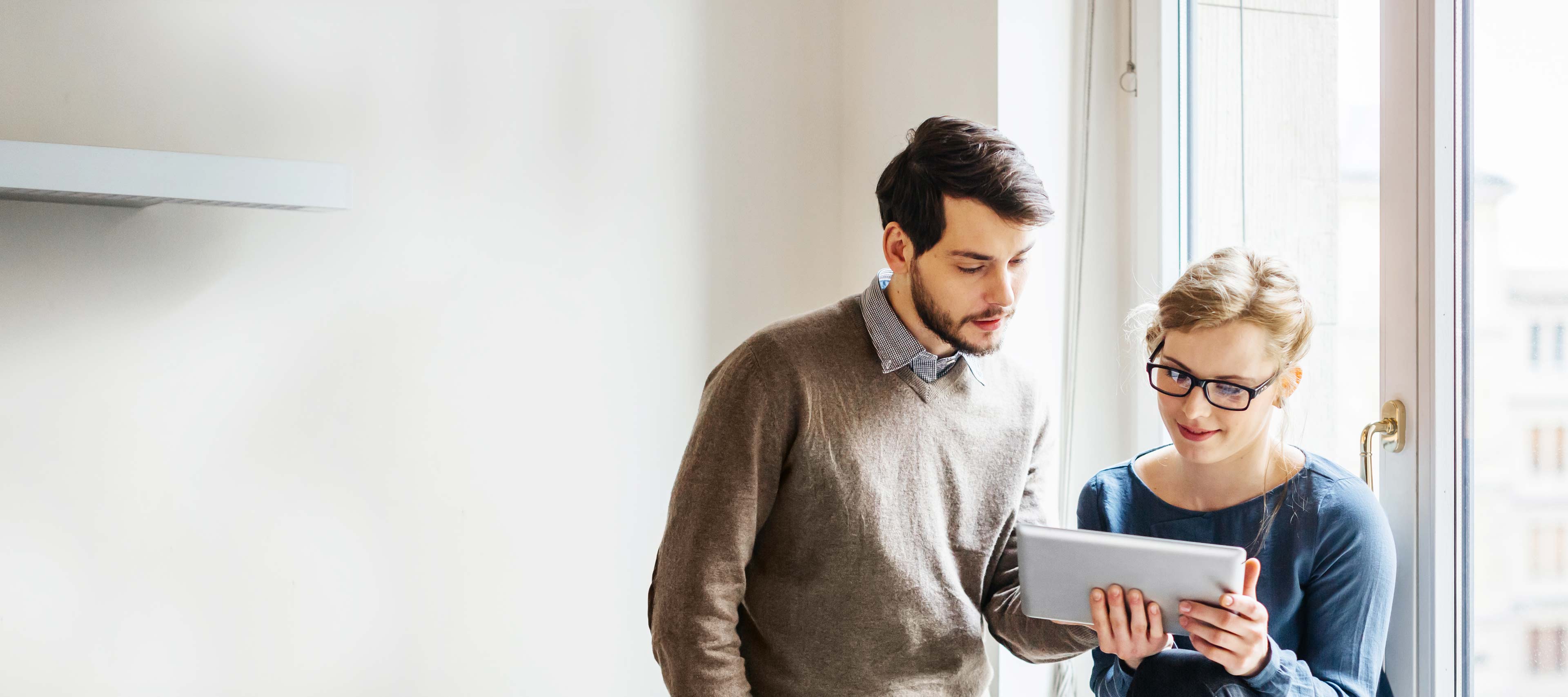 Junges Paar ändert den Abschlag für ihren Energieverbrauch online über ein Tablet