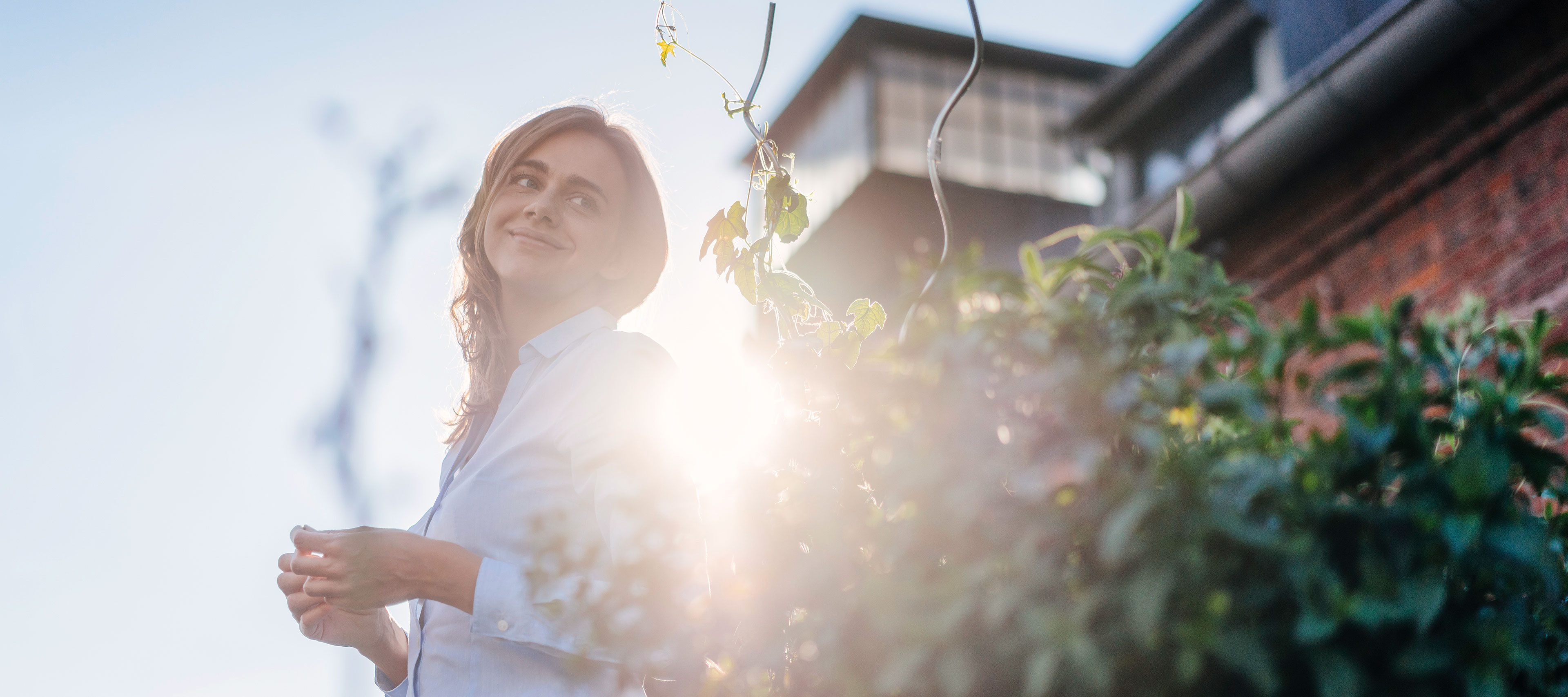 Frau im Garten im Gegenlicht.