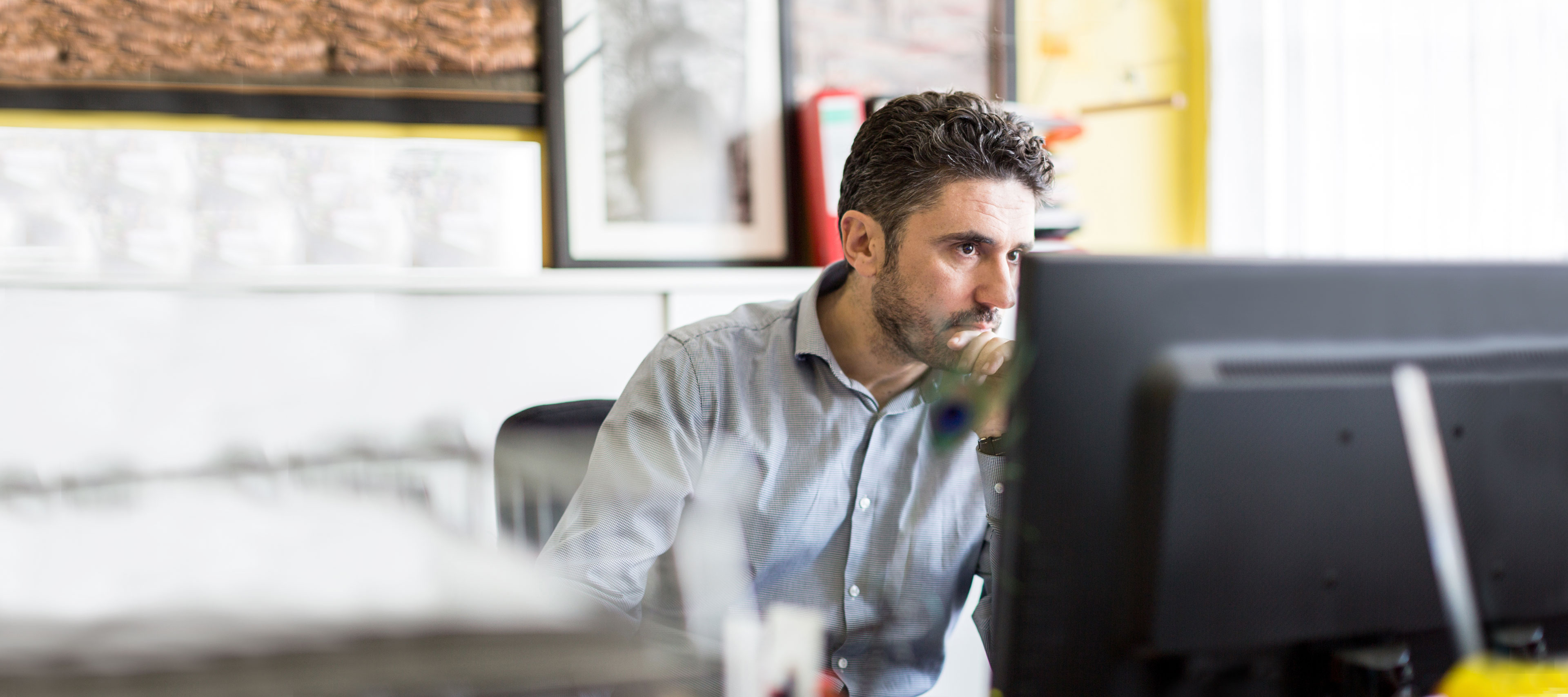 Mann recherchiert nach Bildmaterial am Computer.