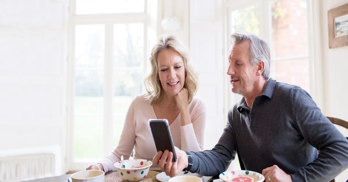 Ehepaar verschafft sich am Handy einen Überblick ihres Energieverbrauchs.