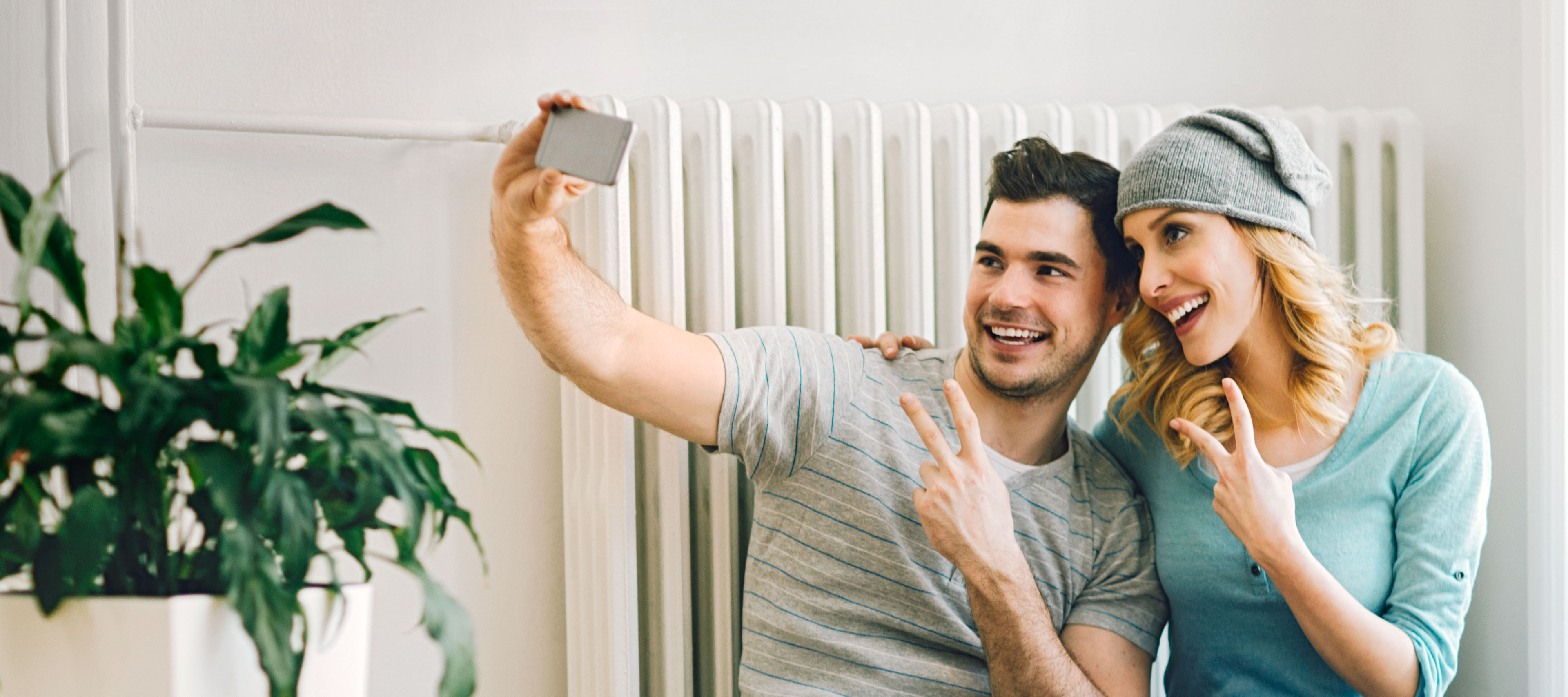 Ein Paar sitzt vor der Heizung und macht ein Selfie.